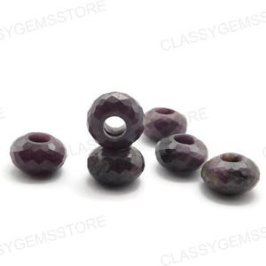 Puede incluir: Seis cuentas facetadas de piedras preciosas de color rojo oscuro con un agujero en el centro. Las cuentas son de un color burdeos intenso y tienen una superficie geométrica multifacética. Las cuentas son probablemente para la fabricación de joyas.