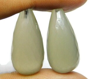 May include: Two teardrop-shaped, faceted, light gray gemstones.