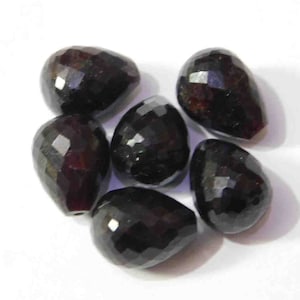 Puede incluir: Seis cuentas de piedra preciosa negra facetadas en forma de lágrima.