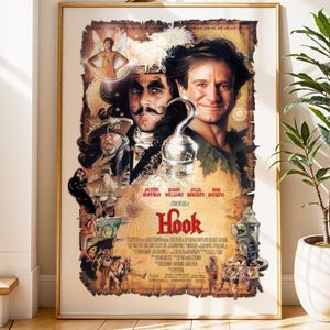 May include: A framed movie poster for the film "Hook" featuring Robin Williams and Dustin Hoffman. The poster has a vintage aesthetic with a gold frame, displayed against a white wall with a staircase and a potted plant.