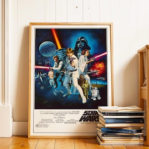 Puede incluir: Un póster enmarcado de la película Star Wars con Luke Skywalker, Darth Vader y la Princesa Leia. El póster tiene un fondo azul con una escena espacial y el logotipo de Star Wars. El póster está en un marco de madera marrón claro.