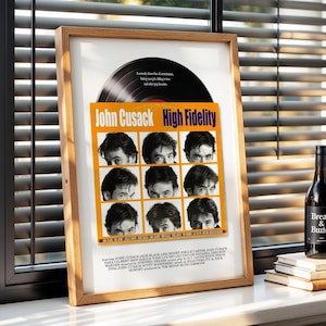 Op de afbeelding: Een ingelijste filmposter voor "High Fidelity" met John Cusack, een vinylplaat en een fles wijn. De poster heeft een oranje achtergrond met negen afbeeldingen van het gezicht van John Cusack. Een fles wijn met een zwart etiket staat naast de poster.