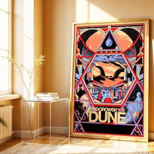 Puede incluir: Un póster enmarcado con un diseño geométrico colorido y el texto "Jodorowsky's Dune". La obra de arte incluye elementos rojos, naranjas, azules y negros, con un marco dorado. El póster está apoyado contra una pared cerca de una ventana.