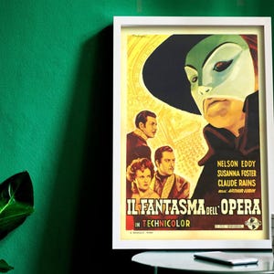 Könnte beinhalten: Gerahmtes Vintage-Filmplakat für "Il Fantasma dell'Opera" in Technicolor. Das Plakat zeigt eine maskierte Figur mit grüner Haut und einem schwarzen Hut sowie Bilder der Schauspieler. Das Plakat befindet sich in einem weißen Rahmen.