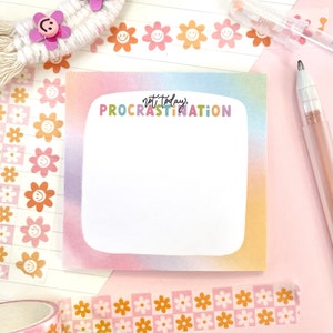 May include: A rainbow gradient notepad with the text "not today, procrastination" in colorful letters. The notepad is surrounded by decorative washi tape with flower and smiley face designs.