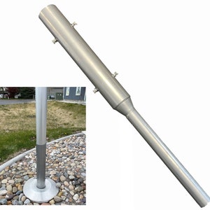 May include: A silver metal flagpole extension with a threaded end. The extension is designed to be attached to a flagpole to increase its height.