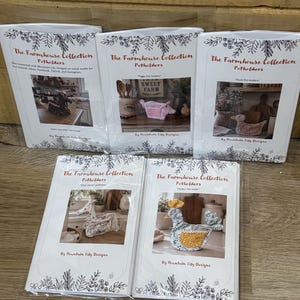 May include: Five white instructional booklets titled The Farmhouse Collection Potholders by Mountain Lily Designs. Each booklet features a color photograph of a unique animal-shaped potholder, including a cow, pig, duck, horse, and chicken.