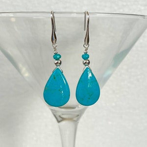 Peut inclure: Une paire de boucles d'oreilles en forme de larme turquoise avec des perles et des crochets argentés.