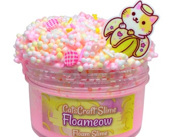 May include: Pink foamy slime with white and yellow foam balls, pink and yellow sprinkles, and a white and orange cat charm holding a banana. The slime is in a clear jar with a pink label that says "CatsCraft Slime Floameow Floam Slime".