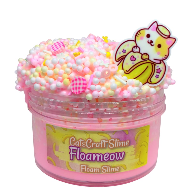 May include: Pink foamy slime with white and yellow foam balls, pink and yellow sprinkles, and a white and orange cat charm holding a banana. The slime is in a clear jar with a pink label that says "CatsCraft Slime Floameow Floam Slime".