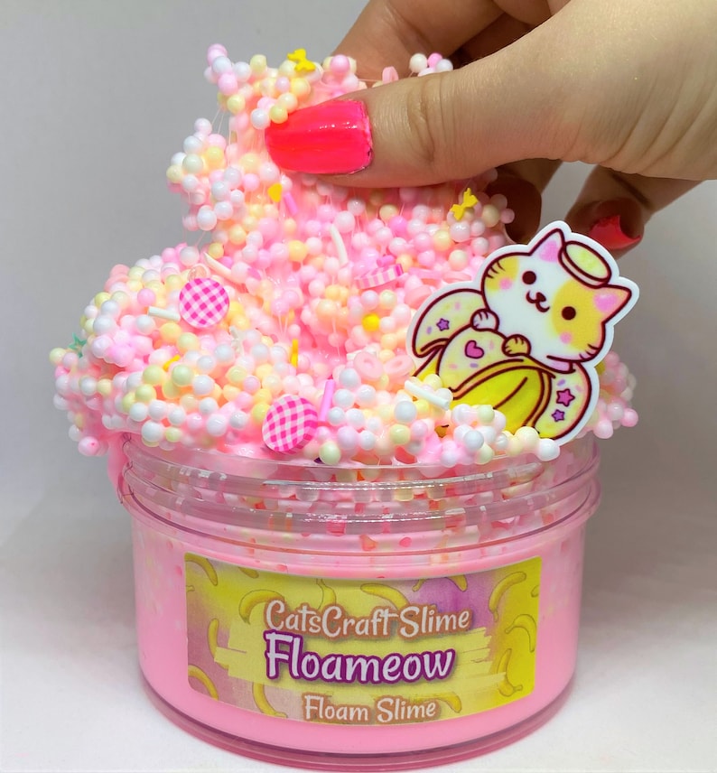 May include: Pink slime with white and yellow beads, a small cat charm with a banana and angel wings, and a label that reads "CatsCraft Slime Floameow Floam Slime".