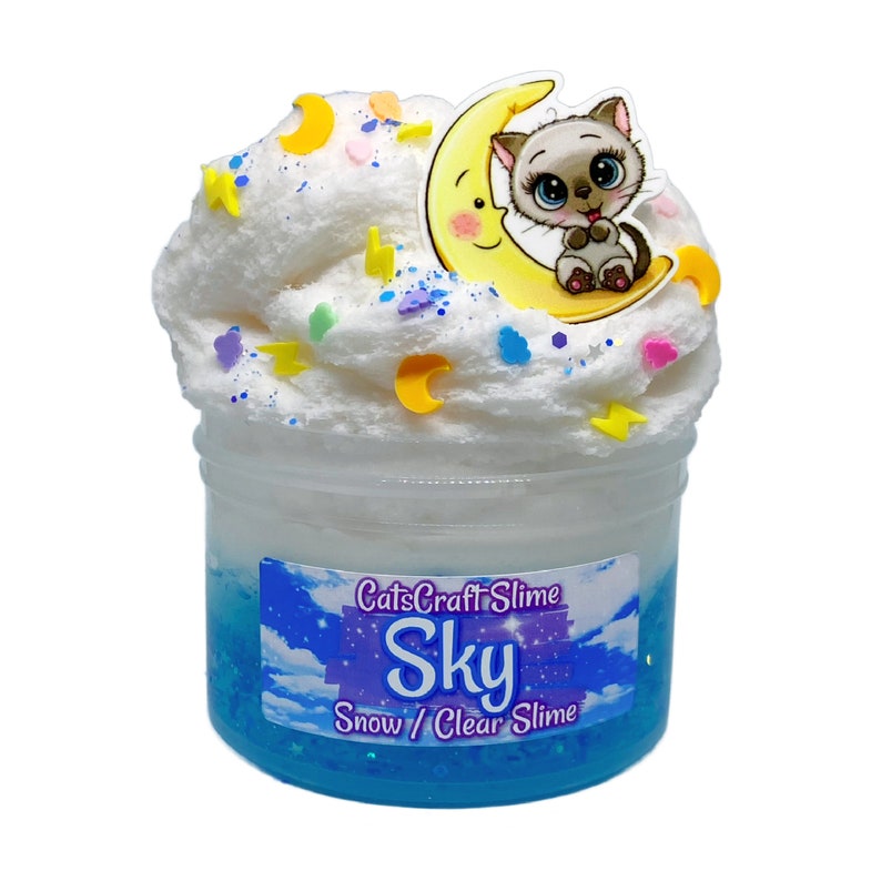 May include: A white fluffy slime with a blue glitter base in a clear jar. The slime is topped with a yellow crescent moon charm with a cartoon cat sitting on it. The jar has a label that reads "CatsCraftSlime Sky Snow / Clear Slime".