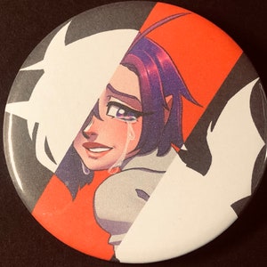 May include: A round button with a colorful illustration of a woman with purple hair, crying tears of joy. The background is a split design of black, white, and red.