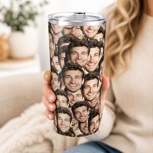 May include: A stainless steel travel tumbler featuring a repeating pattern of smiling faces. The tumbler has a silver lid and a clear plastic top. The design covers the entire surface of the tumbler, creating a unique and personalized look.