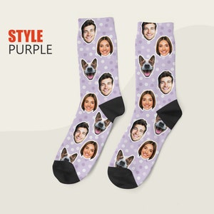 May include: A pair of purple socks with white polka dots. The socks feature a repeating pattern of faces, including a dog, a man, and a woman.