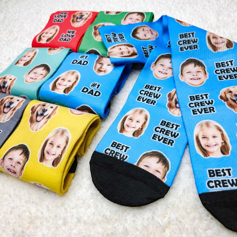 May include: A set of colorful socks with different designs. Some socks feature the text "Best Crew Ever" and others feature the text "We Love Dad" and "#1 Dad".  The socks have a variety of images of people and animals.