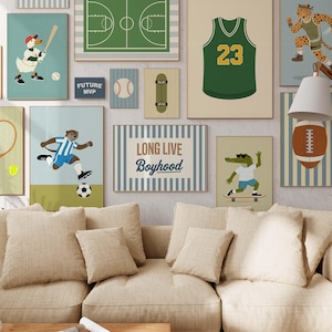 May include: A collection of framed art prints featuring sports themes. The prints include a basketball court, a football jersey with the number 23, a baseball, a skateboard, and a soccer player. The phrase "LONG LIVE Boyhood" is also displayed.