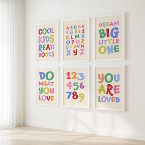May include: Six framed art prints with colorful text on a cream background. The prints feature phrases like "COOL KIDS READ BOOKS" and "DREAM BIG LITTLE ONE", along with the alphabet and numbers.