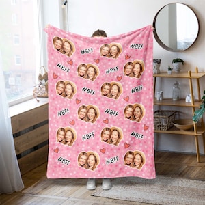 May include: Pink fleece blanket with a repeating pattern of two women's faces and the text "#BFF" in black. The blanket has a white polka dot pattern.