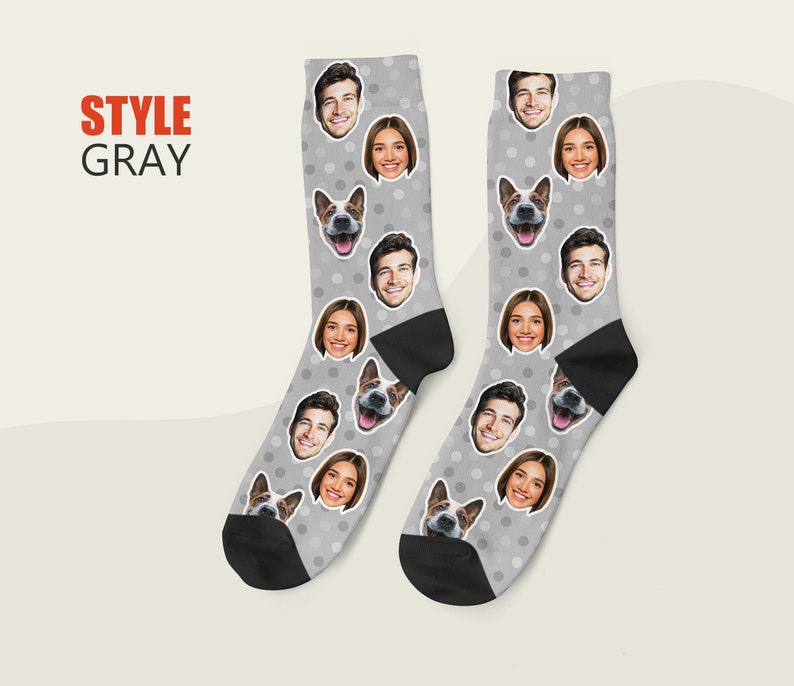 May include: A pair of gray socks with a white polka dot pattern. The socks feature multiple images of people and a dog's face.