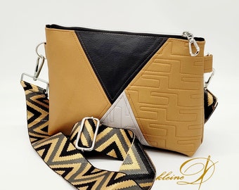 May include: A brown, black, and white crossbody bag with a geometric pattern and a zipper closure. The bag has a black and gold chevron patterned strap.