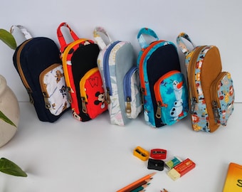 May include: A set of six small, colorful backpacks with various cartoon characters printed on them. The backpacks have zipper closures and adjustable straps.