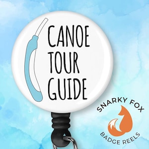 May include: White badge reel with a blue canoe paddle graphic and the text "Canoe Tour Guide". The badge reel is attached to a black retractable cord and a black metal clip. The badge reel is from Snarky Fox Badge Reels.