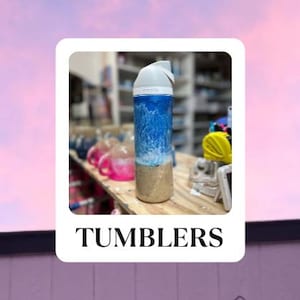 May include: A blue and white tumbler with a wave design. The tumbler is sitting on a wooden table with other tumblers in the background. The text "TUMBLERS" is printed below the image.