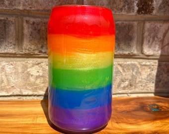 May include: A rainbow-colored can with a glittery finish. The can is made of glass and has a smooth, rounded surface. The colors of the rainbow are red, orange, yellow, green, blue, and purple.