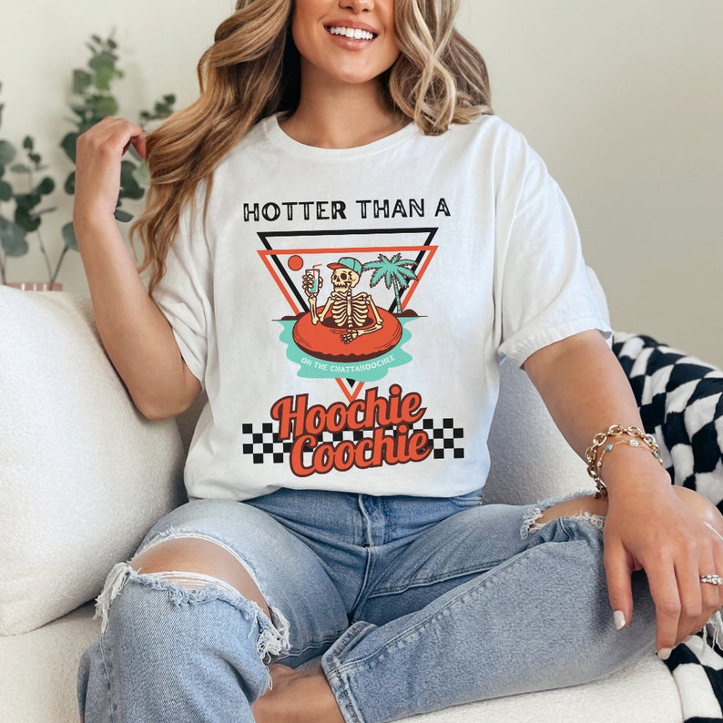 K&ouml;nnte beinhalten: Wei&szlig;es T-Shirt mit einem Grafikdruck eines Skeletts in einem Pool-Schwimmring mit dem Text "Hotter than a Hoochie Coochie" auf dem Chattanooga Choo-Choo.