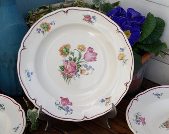 May include: Set of five white ceramic soup bowls with floral designs in shades of pink, yellow, and blue. The bowls have a scalloped edge and a raised rim.