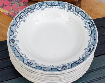 May include: A stack of white ceramic soup bowls with a blue and white floral pattern around the rim.