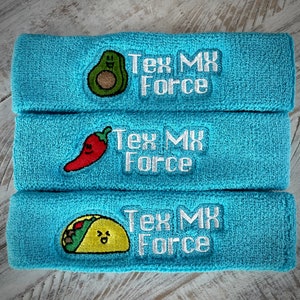 May include: Three stacked, light blue terry cloth headbands. Each headband features an embroidered design and the text "Tex MX Force" in white. The designs include an avocado, a red chili pepper, and a taco.