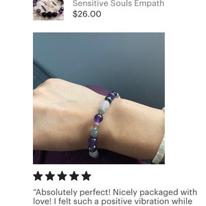 May include: A bracelet made with amethyst, rose quartz, black onyx, and grey hematite beads. The bracelet is on a person's wrist. "Absolutely perfect! Nicely packaged with love! I felt such a positive vibration while opening this! Thank you so much, I love it!"