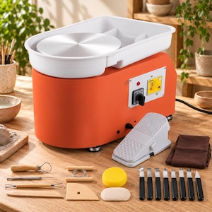 Può includere: Un tornio elettrico per ceramica arancione con una bacinella bianca e un piatto circolare in metallo. Include un pedale, una spugna gialla, una stecca in legno, vari strumenti per scultura in metallo con manici neri e utensili in legno.