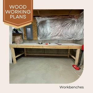 May include: A wooden workbench with a white top and light brown legs. The workbench is in a basement setting, with the words "WOOD WORKING PLANS" in a brown banner in the upper left corner. The word "Workbenches" is at the bottom.