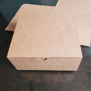May include: A brown cardboard box with a flap on the top. The box is empty and ready to be filled.
