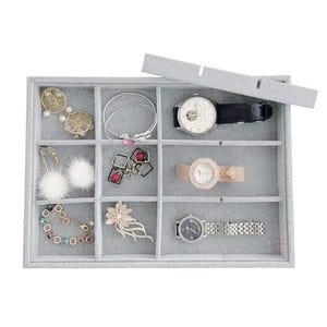 May include: A gray jewelry organizer with multiple compartments, holding various accessories. Items include gold earrings, bracelets, watches with black and tan bands, and a floral brooch. The organizer's lid is partially open.