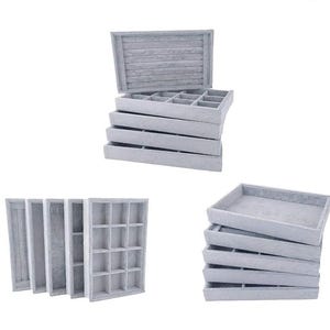 May include: Set of six gray velvet jewelry trays with compartments. The trays are stackable and can be used to organize rings, earrings, necklaces, and other small items.