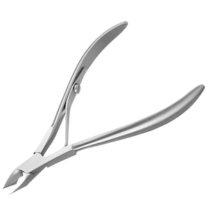 Op de afbeelding: Een zilveren nagelknipper met gebogen handgrepen en scherpe, schuine messen. De nagelknipper is gemaakt van een glanzend, metalen materiaal en is ontworpen voor het knippen van vingernagels en teennagels.