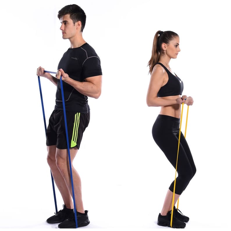 May include: Two people are using resistance bands for exercise. One person is using a blue band and the other is using a yellow band.