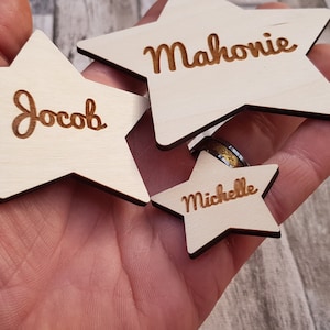 Peut inclure: Trois décorations en bois en forme d'étoile avec les noms Jacob, Mahonie et Michelle gravés dessus.