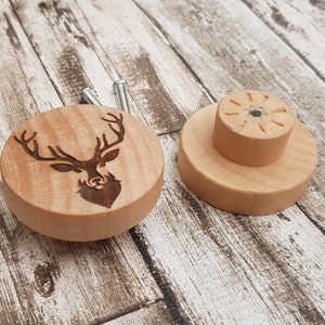 Puede incluir: Dos pomos de madera con un diseño de cabeza de ciervo. Un pomo es de madera lisa y el otro tiene una cabeza de ciervo tallada.