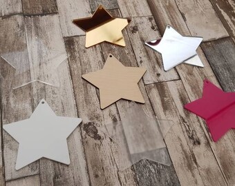 May include: Six different star-shaped acrylic ornaments in various colors, including gold, silver, white, clear, and pink. The stars are all the same size and have a hole at the top for hanging.