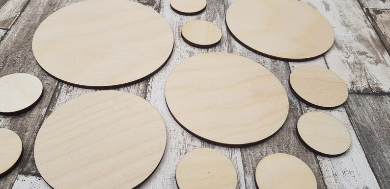 May include: A set of 10 unfinished wooden circles of varying sizes. The circles are made of light-colored wood and have a smooth surface.