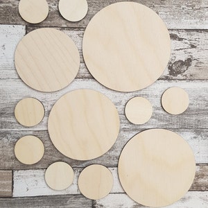 May include: A set of ten unfinished wooden circles of varying sizes, perfect for crafting projects. The circles are arranged on a light brown woodgrain background.