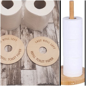 May include: Two wooden signs with the text "Last Roll Left, Refill Toilet Paper" and a wooden toilet paper holder with three rolls of toilet paper.