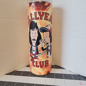May include: A stainless steel tumbler with a graphic of two cartoon characters playing guitars in front of flames. The text "Hell Yeah Club" is printed on the tumbler.