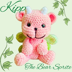 K&ouml;nnte beinhalten: Rosa geh&auml;kelter B&auml;r mit gr&uuml;nen Fl&uuml;geln, genannt "Kipp the Bear Sprite".