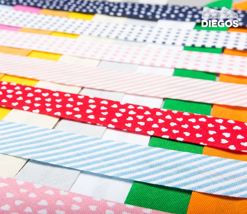 May include: A collection of colourful fabric ribbon trims with various patterns, including polka dots, stripes, and hearts. The ribbons are arranged in a layered pattern, creating a visually appealing display.